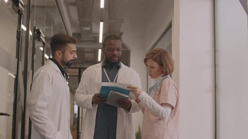 Doctors Discussing Patient Care in Hospital Corridor