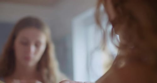 Blonde Woman Puts on Earring in Mirror Close Up