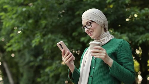 Beautiful Young Woman with Hijab Working Using Smartphone During Coffee Break