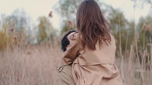 Woman and Man in Beige Coats Having Date in Reeds