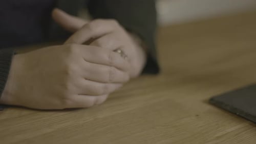 A woman fidgets, close-up of hands.