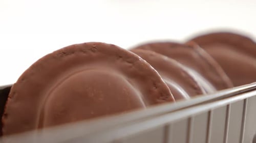 Paced chocolate glazed orange biscuits on white background slow panning 4K 2160p UltraHD close-up f