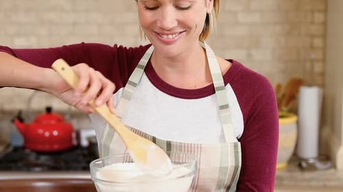 Woman Cooking in Kitchen Stirring Bowl with Spoon