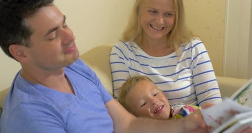 Dad and Mom Reading Book to Son
