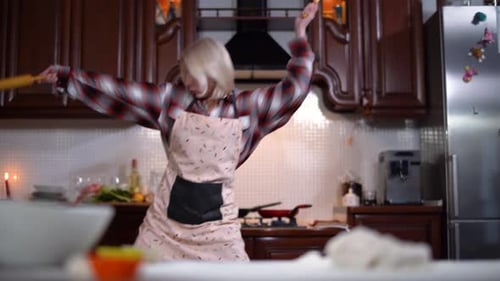 Joyful Blond Beautiful Woman Imitating Fencing with Rolling Pin