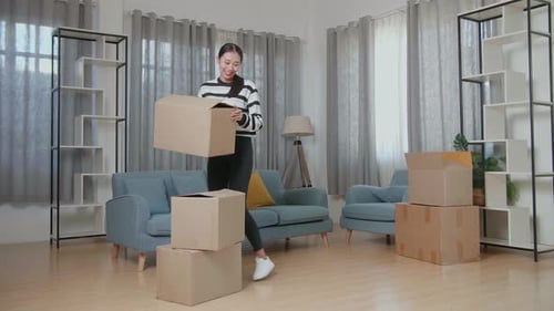 Woman Moving into New Home with Cardboard Boxes