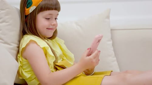 Girl Reclining on Couch Using Pink Cell Phone