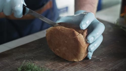 Fast Food, Male Chef Cuts on Cutting Board with Kitchen Knife Fresh Hot Hamburger Bun Taken Out of