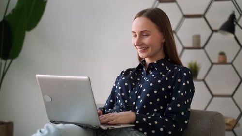 Woman Using Laptop in Living Room