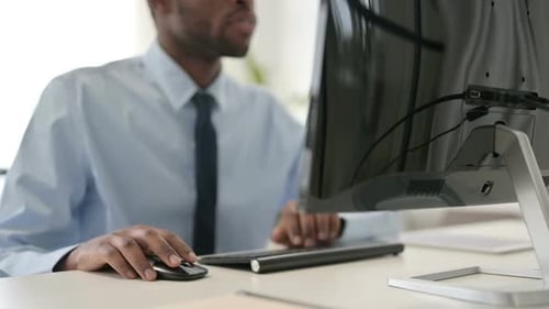 Geschäftsmann arbeitet mit Maus und Tastatur am Desktop