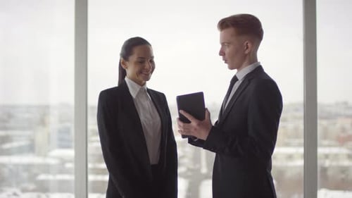 Business Professionals Discussing Data on Tablet in Office