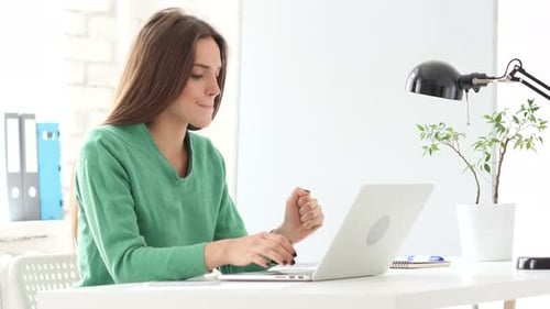 Woman Working on Laptop with a White Desk