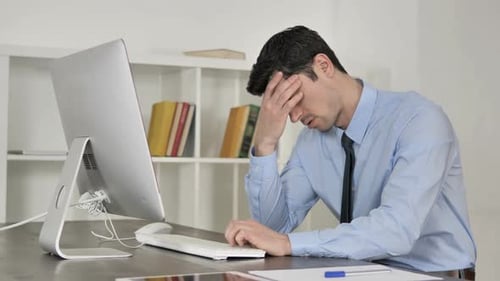 Stressed Young Adult Typing on Computer in Office