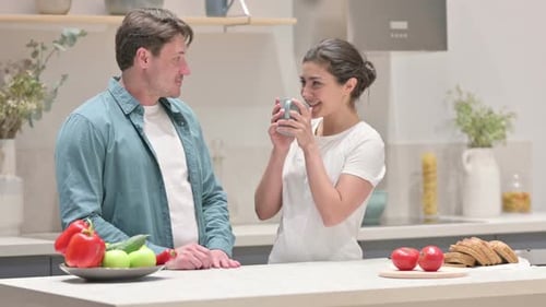 Couple Chatting in Sunny Kitchen with Fruit