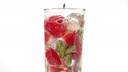 Fresh Strawberries and Mint Being Poured Over Ice
