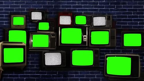Many Old Televisions with Green Screens and Static over Blue Brick Wall.