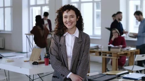 Young Woman Smiling in Modern Workplace with Colleagues