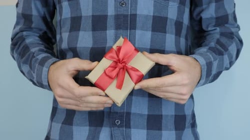 Adult Holds Small Wrapped Birthday Gift Close Up