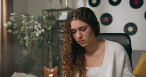 A Young Woman with Curly Hair She Works From Home at a Desk