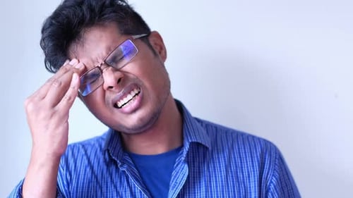 Young Man Frustrated and Suffering Headache, Close Up