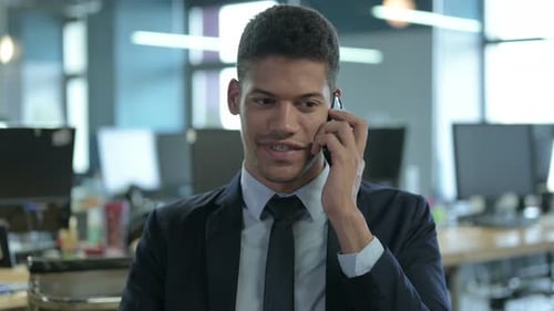 Smiling Young Adult in Suit Talking on Phone