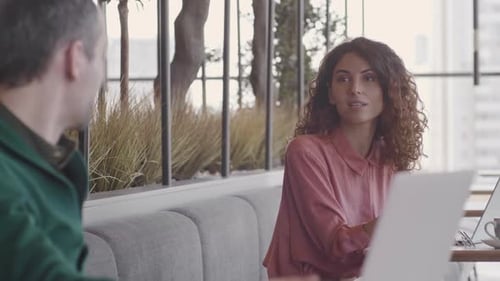 Two People Communicating in Coworking Cafe