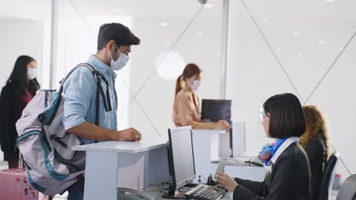 Passenger Checks In At Airport With Face Mask