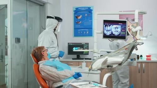 Dentist Showing Teeth X-Ray to Patient in Clinic