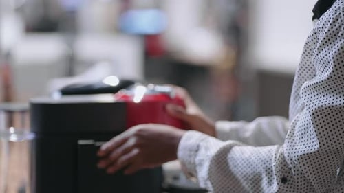 Afroamerican Woman is Choosing Automatic Coffee Maker for Home or Office Closeup View of Hands of