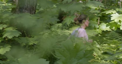 Active Young Woman Running in Nature on Path in Dense Green Forest. Slow Motion. Healthy Lifestyle C