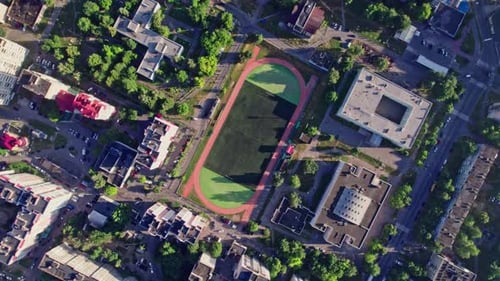 Buildings with Street in Small Town with Empty Football Soccer Field