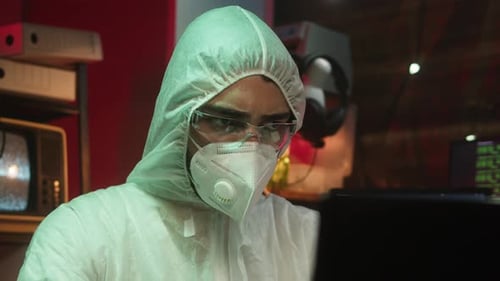 Person in Hazmat Suit in front of Laptop