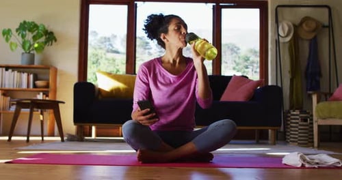 Woman Hydrating After Exercise With Smartphone