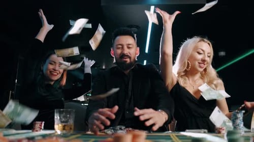 Two Young Women and Bearded Man Are Winning and Rejoice in Victory at the Casino and Throw Money in