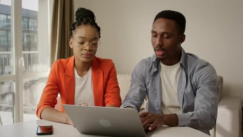Young Adults Working Together on Laptop Indoors