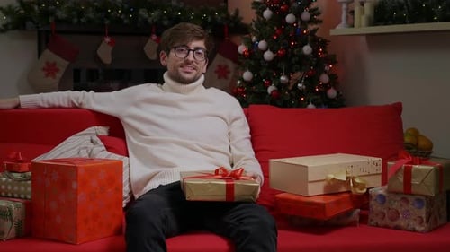 Man With Christmas Gifts on Red Couch