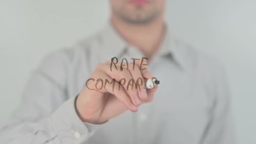 Man Writes Rate Comparison on Glass Surface