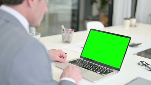 Empresario usando una computadora portátil con pantalla de teclado Chroma verde