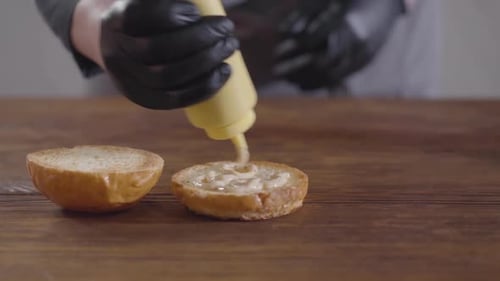 Applying Sauce to Hamburger Bun Close Up
