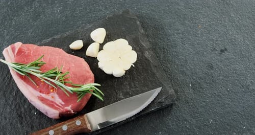 Raw Meat with Garlic and Rosemary on Stone