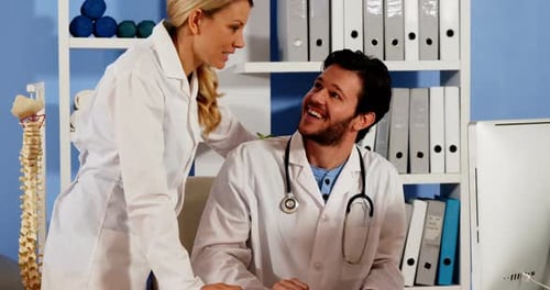 Two Doctors Collaborating on Computer in Office