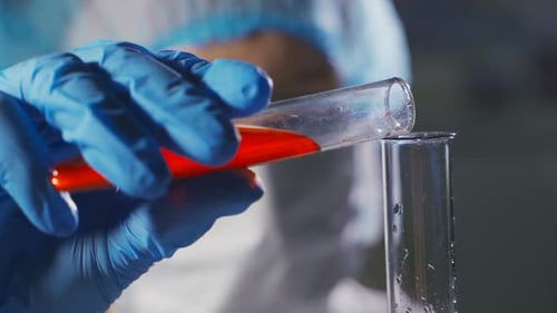 Scientist Pours Orange Liquid in Test Tube