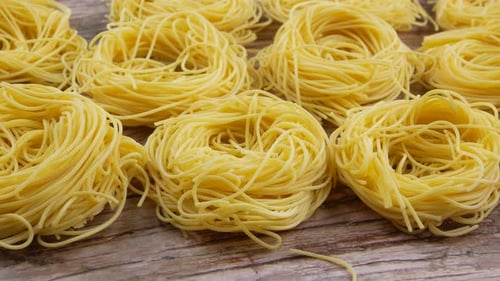 Dried Egg Noodles on Wooden Surface, Close Up