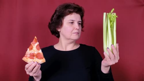 Woman Eats Pizza While Holding Celery