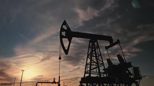 Industrial Oil Pumpjack Silhouette at Colorful Sunrise