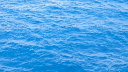 Hintergrund von Calm Sea. Meer mit kleinen Wellen hautnah. Blaues Meer mit Little Waves Textur.