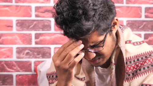 Young Man Frustrated and Suffering Headache Close Up