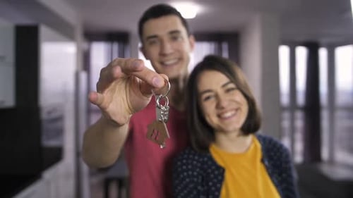 Young Happy Couple Holding Keys in New Home