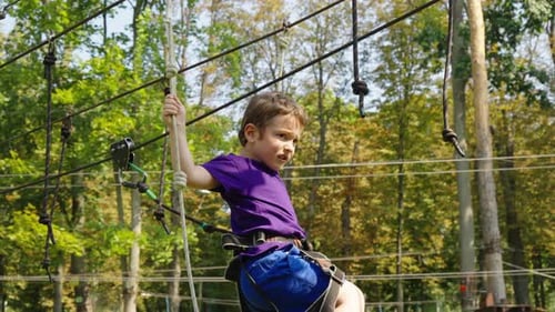 Child Climbing Rope Trail in Amusement Park