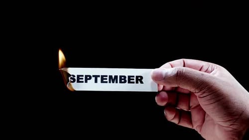 Hand Holding Card with September on Fire